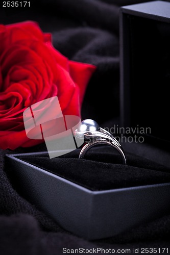 Image of red rose and diamond ring in a box 