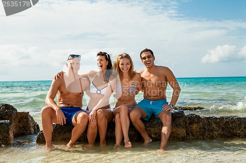 Image of young happy friends havin fun on the beach