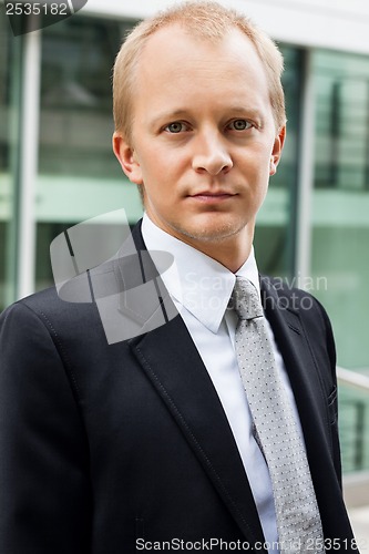 Image of smiling successful business man in black suit outdoor