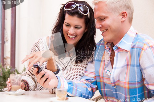 Image of young smiling couple in cafe outdoor in summer