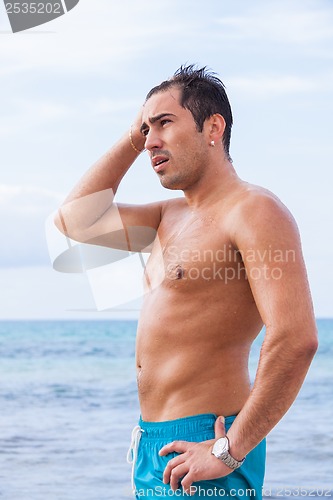 Image of attractive young athletic man on the beach
