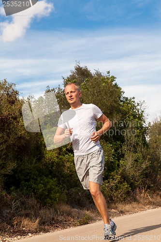 Image of athletic man runner jogging in nature outdoor