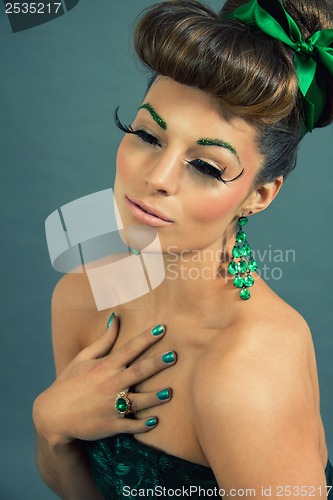 Image of brunette woman with green jewelery and accssesoires