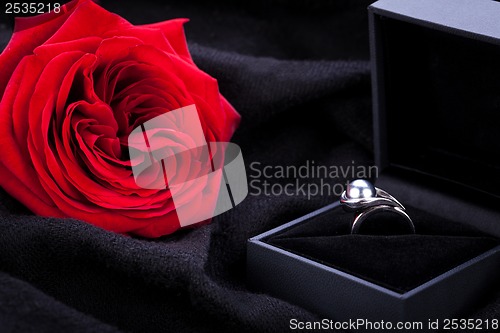 Image of red rose and diamond ring in a box 