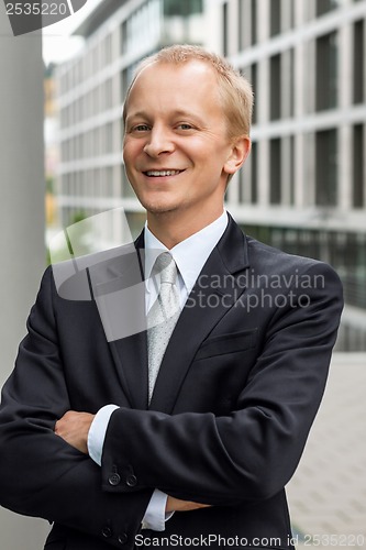 Image of smiling successful business man in black suit outdoor