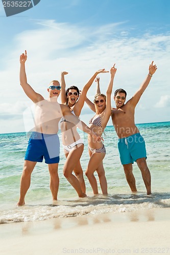 Image of young happy friends havin fun on the beach