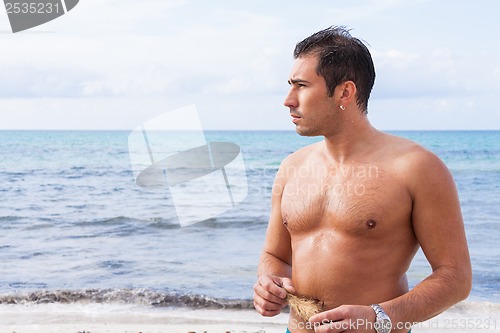 Image of attractive young athletic man on the beach