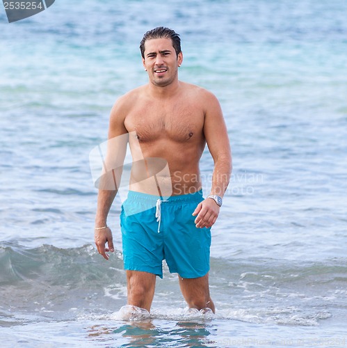 Image of attractive young athletic man on the beach