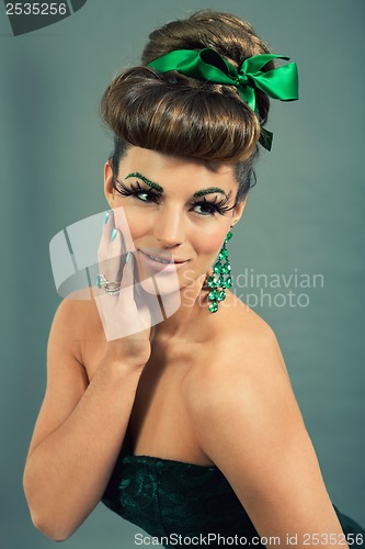 Image of brunette woman with green jewelery and accssesoires