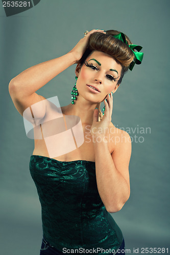 Image of brunette woman with green jewelery and accssesoires