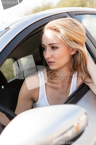 Image of young attractive happy woman sitting in car summertime