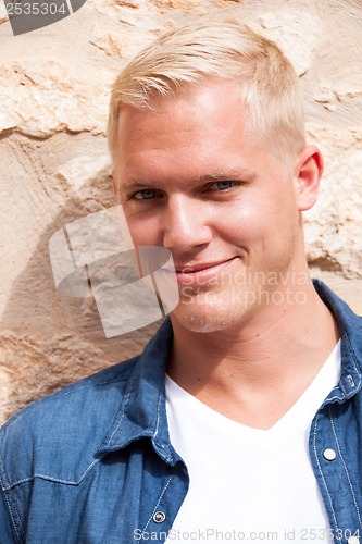 Image of attractive young adult man standing outside 