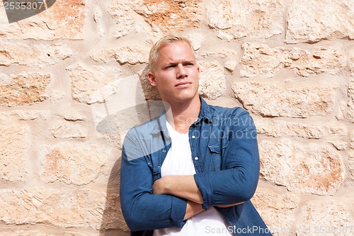 Image of attractive young adult man standing outside 