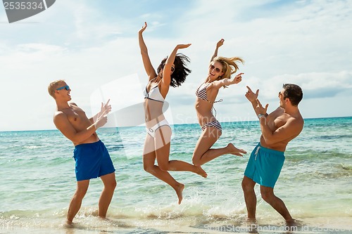 Image of young happy friends havin fun on the beach