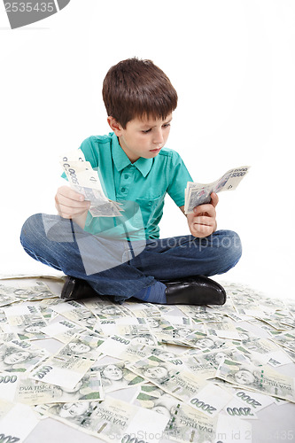 Image of boy sitting on money, money concept