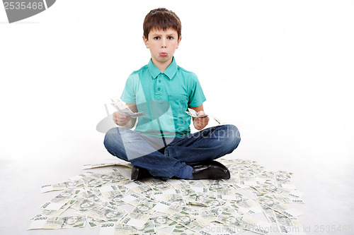 Image of boy sitting on money, money concept