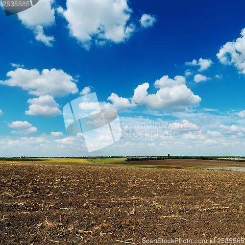 Image of blue cloudy sky over plowed field