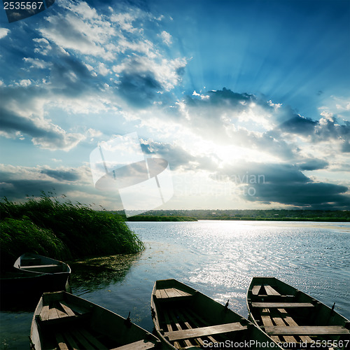 Image of boats on river and sunset over it