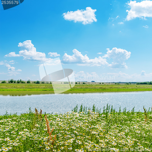 Image of river in green grass under cloudy sky