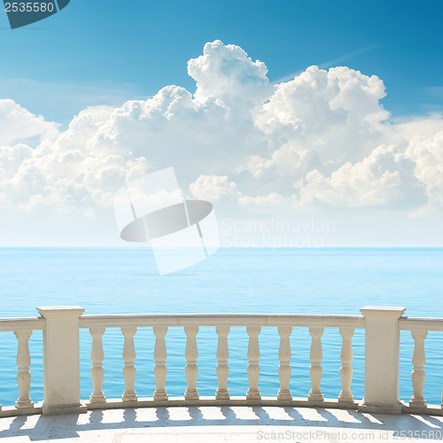 Image of cloudy sky over sea and balcony