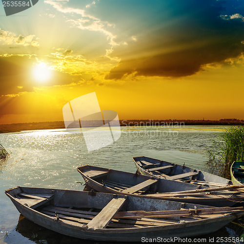 Image of yellow sunset over river with boats