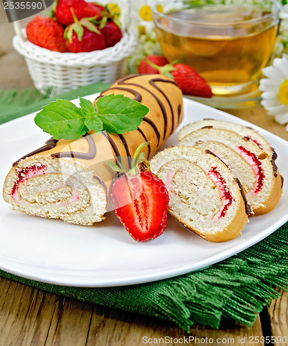 Image of Roulade a cup of tea and strawberries on a board