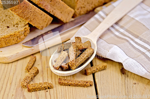 Image of Rye homemade bread with croutons in spoon on a board