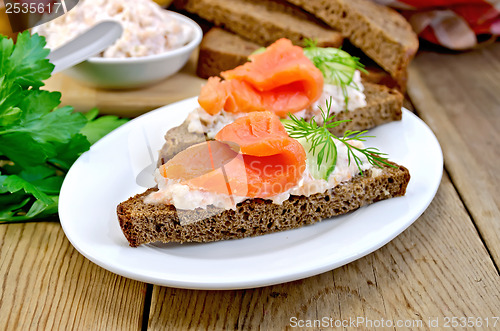 Image of Sandwich with salmon and cream in a dish with cucumber