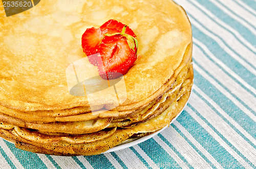 Image of Pancakes on a plate with strawberries on a napkin
