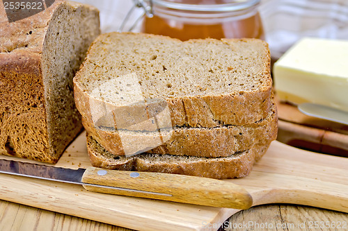 Image of Rye homemade bread stacked with honey and knife