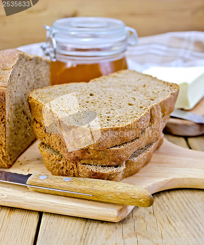 Image of Rye homemade bread stacked with honey on a board