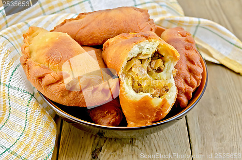 Image of Patties fried with cabbage and meat on board