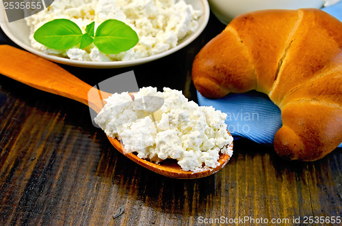 Image of Curd on a wooden spoon on a board