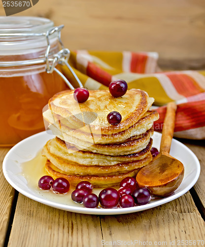 Image of Flapjacks with cranberry and a jar of honey on the board