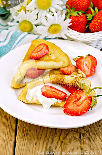 Image of Pancakes with strawberries and cream on the board