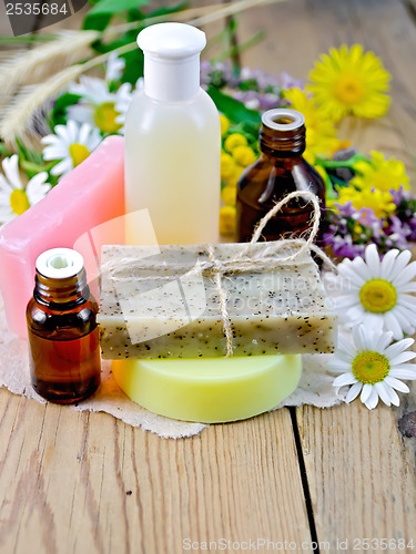 Image of Oil with lotion and soap with wildflowers on the board