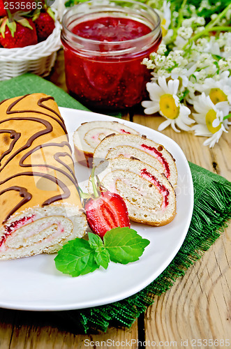 Image of Roulade with strawberries and daisies on a board