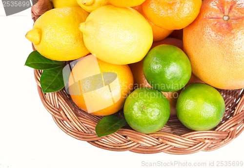 Image of Fresh citrus fruit with leaves in a wicker basket