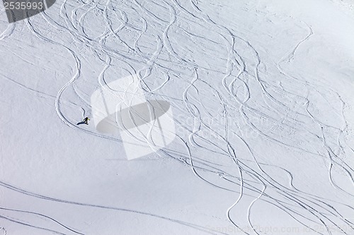 Image of Snowboarder downhill on off piste slope with newly-fallen snow