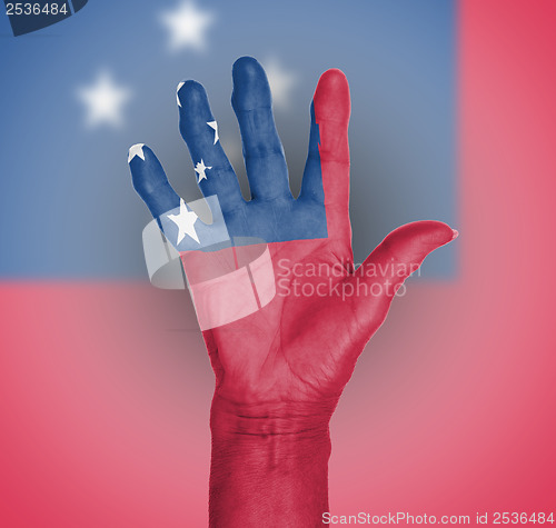 Image of Palm of a woman hand, painted with flag