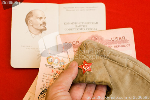 Image of party card with forage cap in hand over red