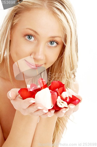 Image of happy blond in spa with red and white rose petals