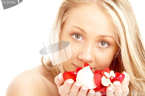 Image of happy blond in spa with red and white petals