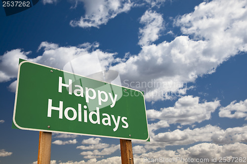 Image of Happy Holidays Green Road Sign Over Clouds and Sky