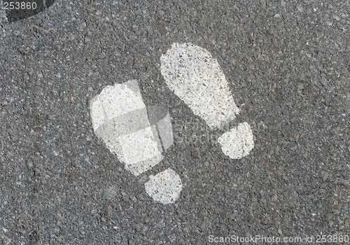 Image of Painted footprints on asphalt