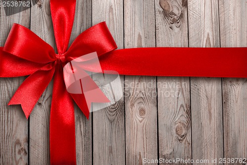 Image of Red ribbon on a wooden background