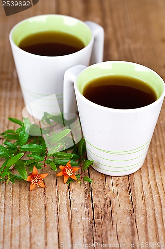 Image of two cups of tea and flower 