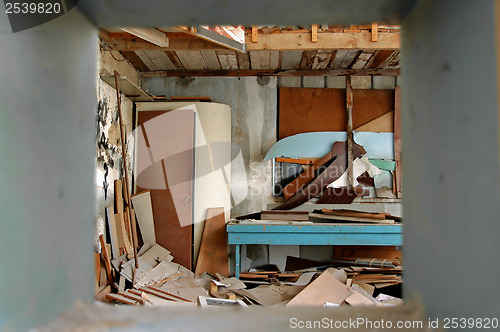 Image of ramshackled room with boarded up window 