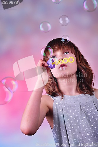 Image of holiday portrait of happy child blowing soap bubbles