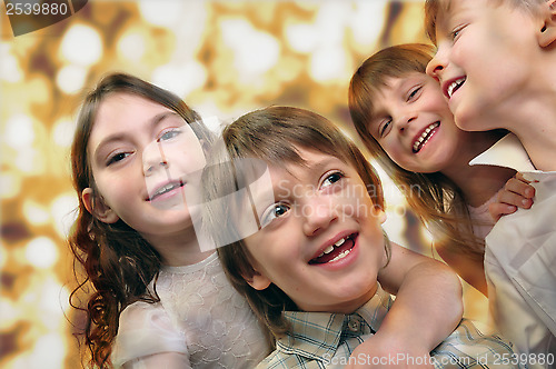 Image of holiday portrait of happy children against bright golden backgro